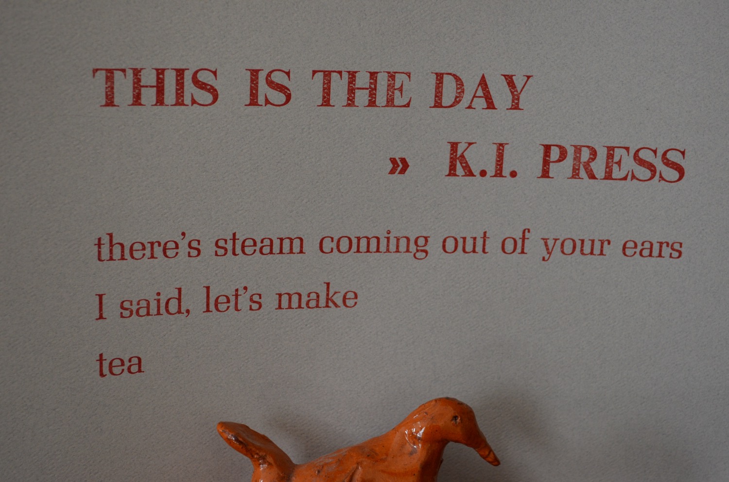Broadside reading 'THIS IS THE DAY - K.I. PRESS / there's steam coming out of your ears/I said, let's make / tea
