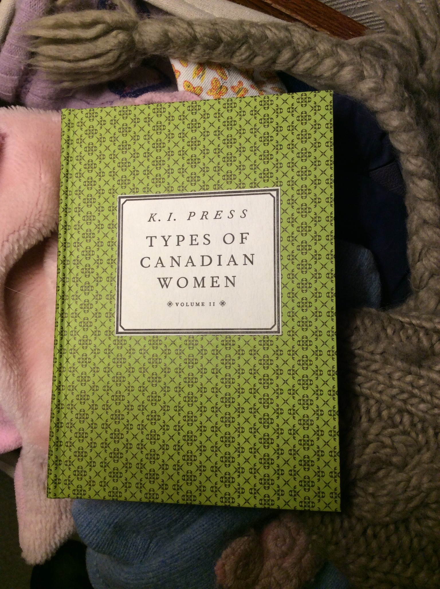 Book Types of Canadian Woman sitting on a pile of winter hats.